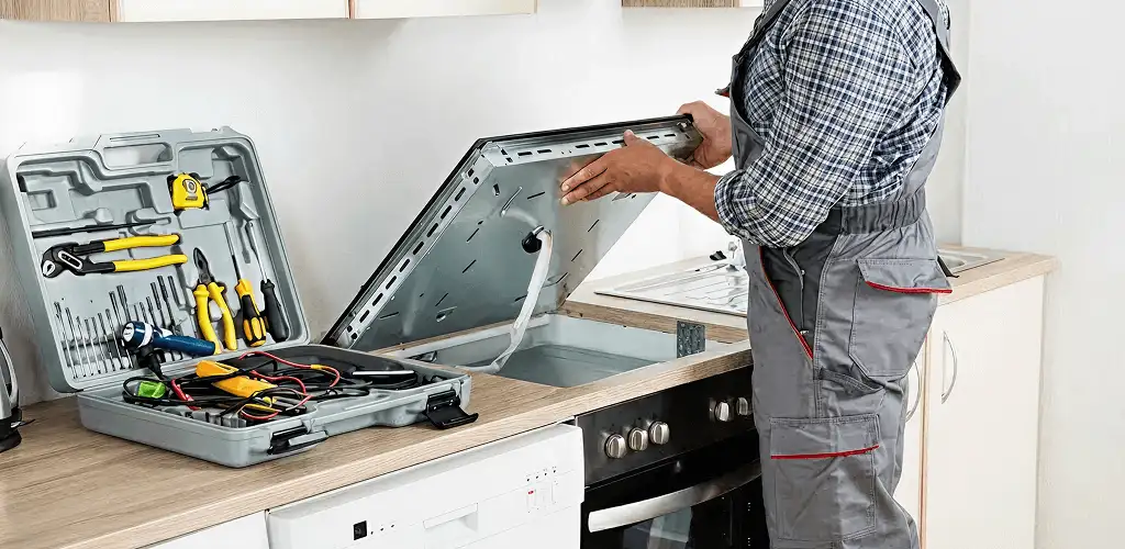 Handyman repairing a cooktop and checking wiring connections in Marietta, GA