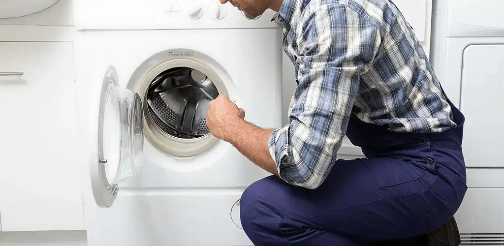 Handyman inspecting a dryer drum and internal parts for repair in Marietta, GA