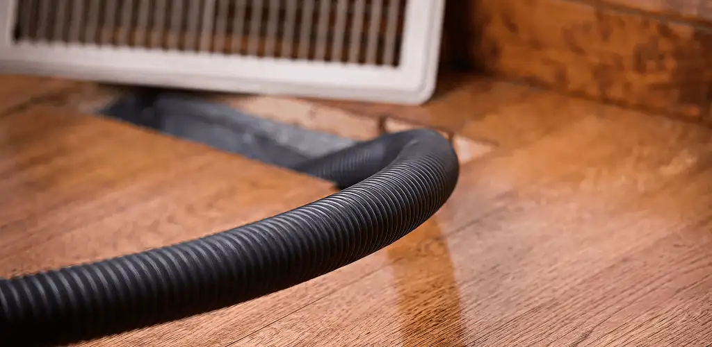Air duct cleaning hose inserted into a floor vent for ductwork cleaning in Marietta, GA