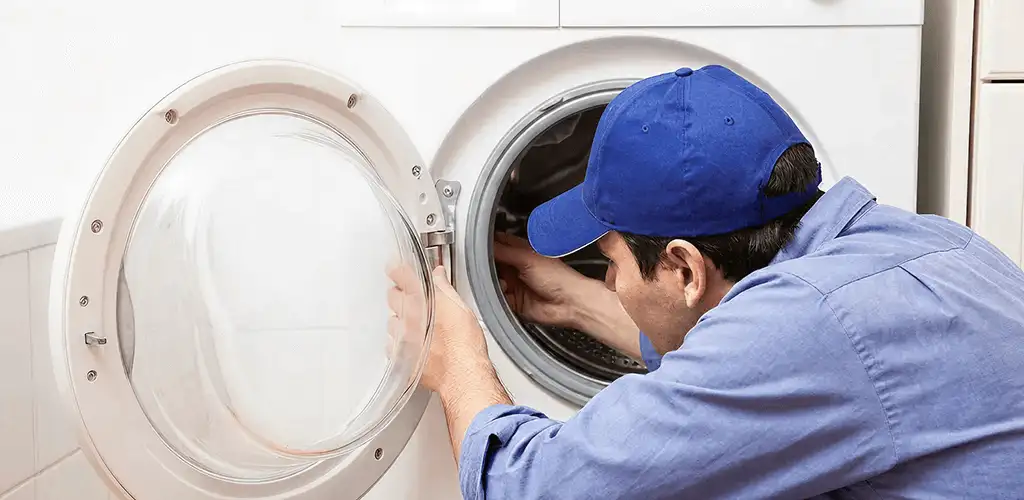 Washing machine repair handyman inspecting a front-load washer drum in Marietta, GA