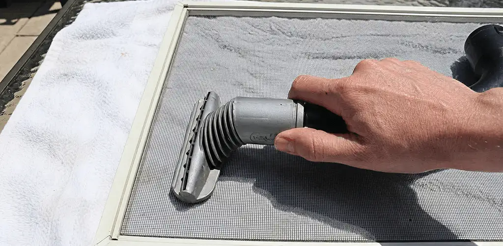 Window screen repair cleaning and fixing a damaged screen mesh in Marietta, GA